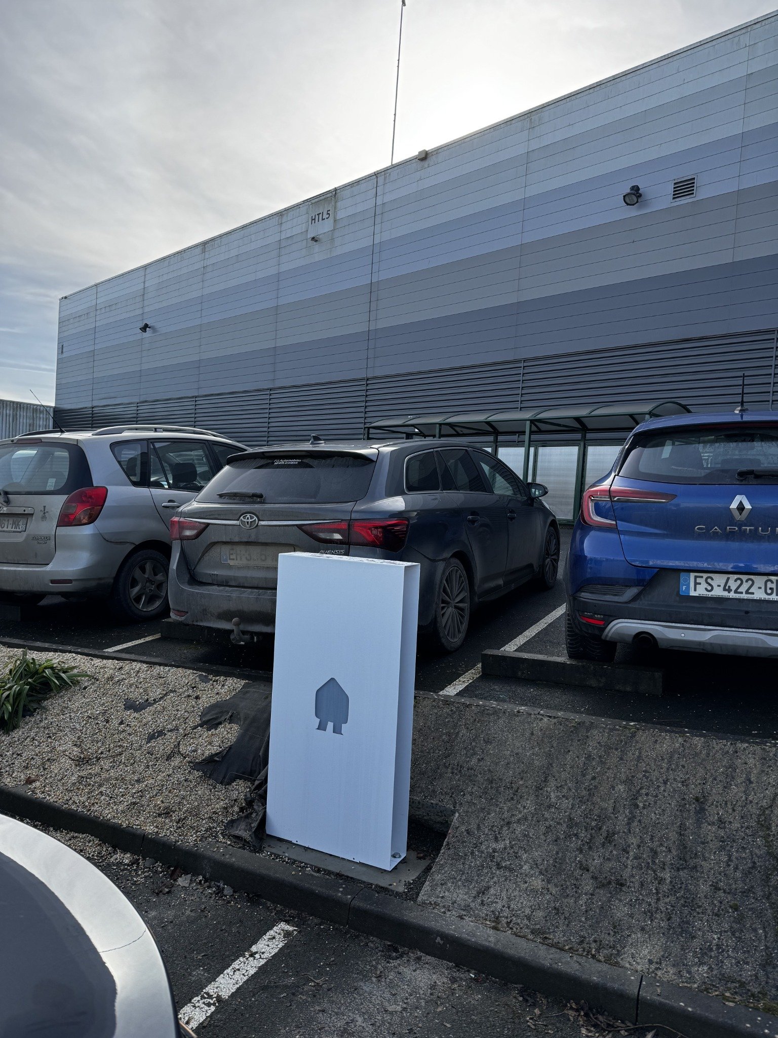Borne de recharge installée au bord d’une place de stationnement.